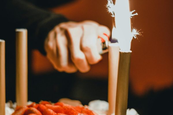 A captivating image of a birthday cake adorned with lit sparklers and fresh strawberries.